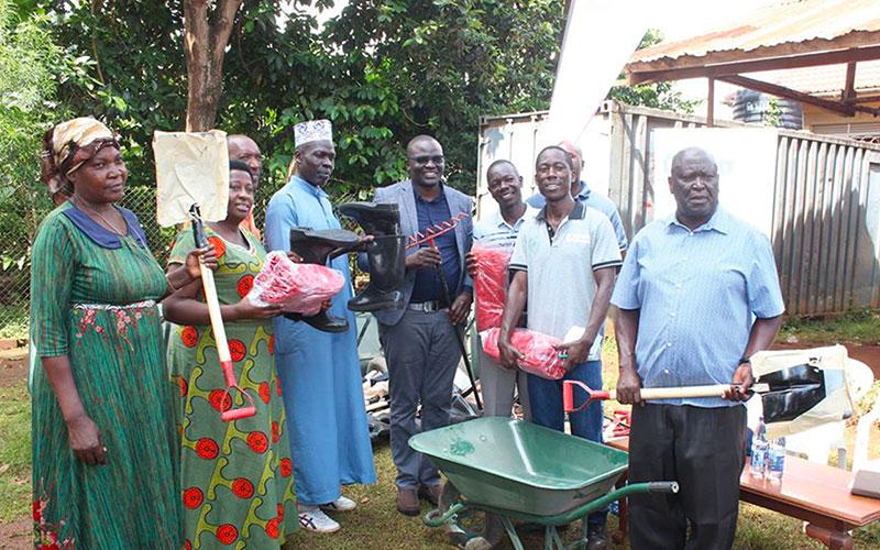 CiplaQCIL Company Pharmacist and Director, Mr Sam Opio, hands over sanitation tools to leaders of the Luzira community.